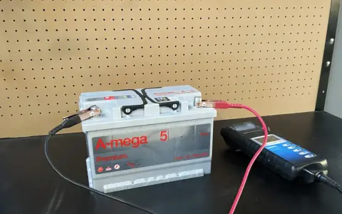 Akumulator samochodowy podłączony do testera za pomocą klem.
