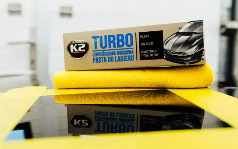 Pudełko pasty do polerowania K2 Turbo i żółta ściereczka z mikrofibry.