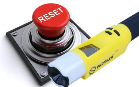Żółty alkomat Promiler obok czerwonego przycisku RESET.